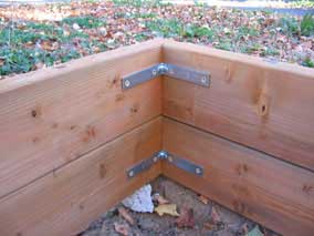 Metal brackets at corner of planting bed wall