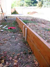 Stakes along planting bed wall