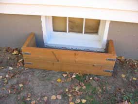 New pressure treated window well at basement window