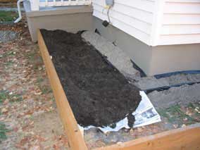 Some soil and pea gravel spread around planting bed