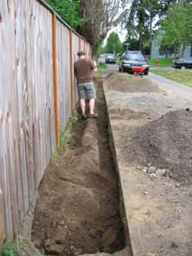 Clearing loose fill out of the trench after running post auger