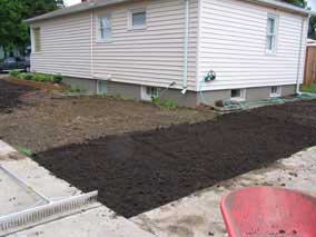 More graded topsoil on back yard into side yard