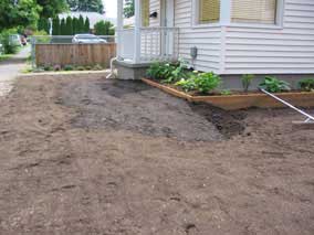 Banked topsoil against front of planting bed