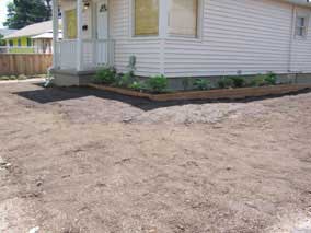 Banked topsoil against front and side of planting bed