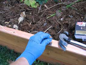 Nailing copper nails through copper slug barrier and wood planter wall