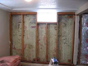 Green and white paisley wallpaper on basement foundation wall