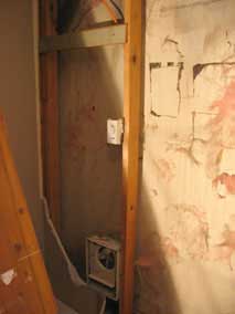 Electric wall heater and wiring exposed on west wall of basement