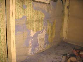 Scraping wallpaper off the concrete walls