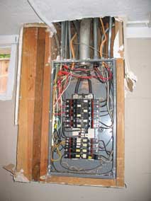 Old electrical panel while demolishing wood and drywall enclosure