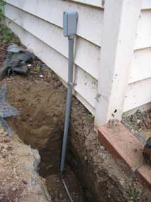 New wiring coming up from trench into back corner of garage