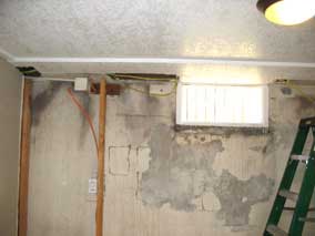 Electrical wire running through basement ceiling along outside wall