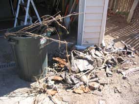 Junk pulled out of ground next to garage