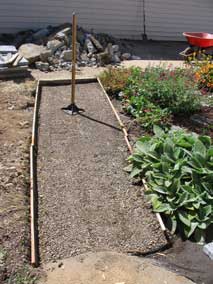 Tamping down sand and gravel base for new pavers