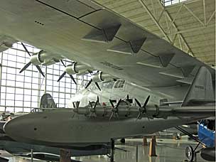 Scale model of the <em>Spruce Goose</em> under the wing of the actual plane