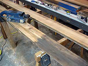 Using belt sander to clean up shiplap board