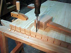 Chopping dovetail waste on tool chest panel