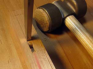 Driving mortise chisel into leg