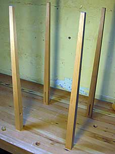 Four tapered legs upsidedown on workbench