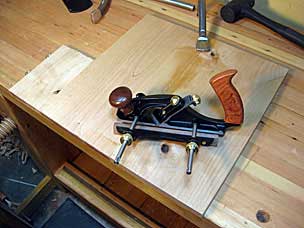 Preparing to bevel underside of nightstand top with skew rabbet plane